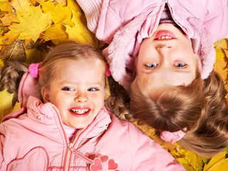 Kids in autumn orange leaves.