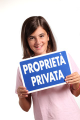 adolescente mostra cartello "proprietà privata"