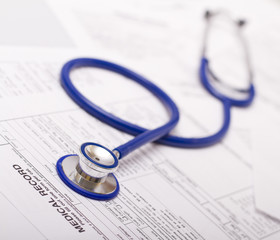 A prescription form and stethoscope on a doctor's desk