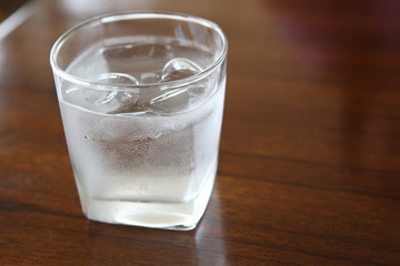 Glass with water on wood background