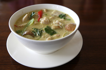 Thai food chicken green curry with rice in wood background