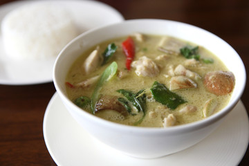 Thai food chicken green curry with rice in wood background