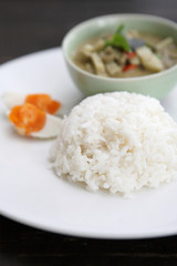 Thai food chicken green curry with rice in wood background