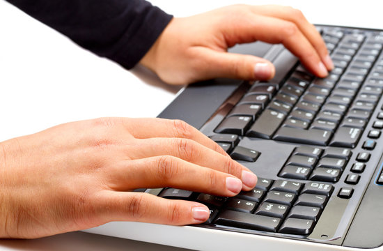 Female hands writing on computer keyboard