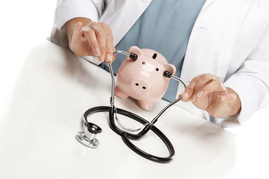Doctor Holds Stethoscope to Ears of Pink Piggy Bank