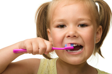 Little girl is cleaning teeth using toothbrush