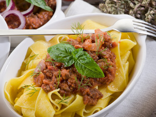 pappardelle bolognese with ragout sauce and basil leaf