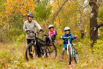 Fototapeta na wymiar Family cycling outdoors, golden autumn in park
