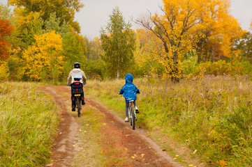 Obraz premium Family cycling outdoors, golden autumn in park