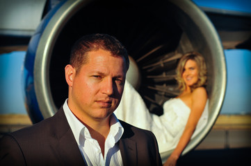 young wedding couple standing at intake of Boeing engine