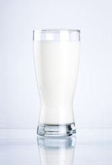 Glass of fresh milk on a gray background