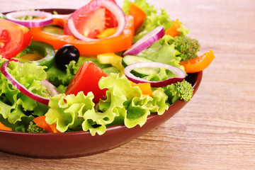 many vegetables on the plate on a wooden background