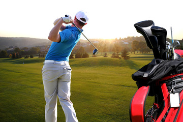 Man playing golf with golf bag