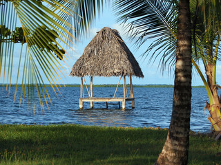 Tropical hut over water with thatched palm roof,  Caribbean sea, Panama