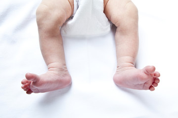 newborn baby feet over white background