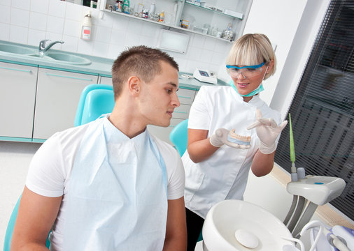 dentist showing patient dental protese
