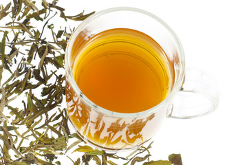 tea in glass cup and dried leaves