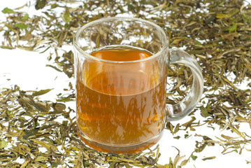 tea in glass cup and dried leaves