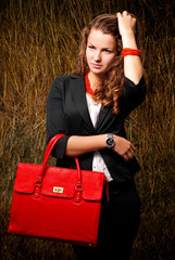Young womans portrait having red bag in hand.