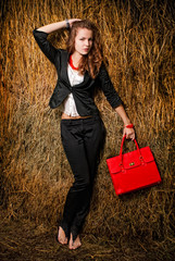 Young womans portrait holding red bag in hand.