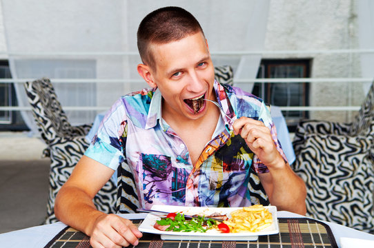 Young man eating up meat