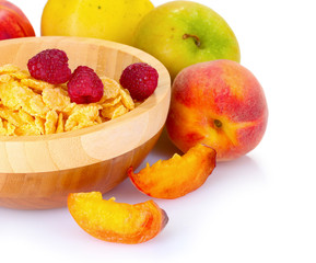 tasty cornflakes and fruit in wooden bowl isolated on white