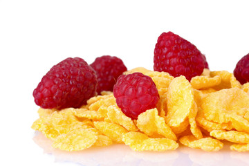 tasty cornflakes and raspberries isolated on white