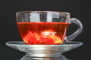 black tea and fruit in cup on black  background