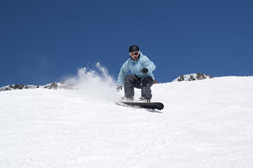Naklejka na ściany i meble Snowboarding in snowy mountains