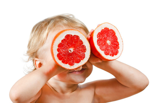 Little boy with a pink grapefruit on a white background