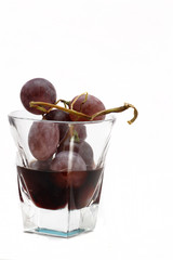 uva rossa in bicchiere con vino