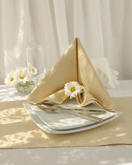 Napkin folded into a "corner" with a knife and fork