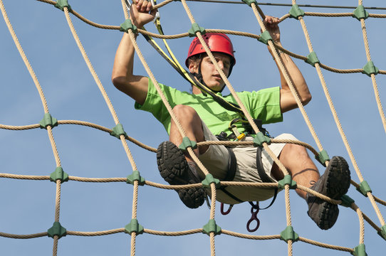 junger Sportler im Hochseilgarten - Powered by Adobe