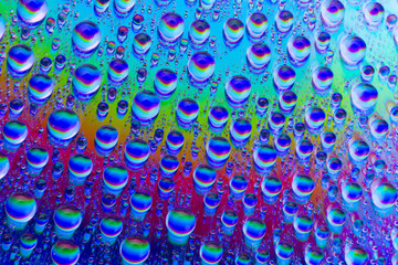 Multicolored drops of water, rainbow background