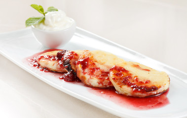 Cheese pancakes with cherry sauce