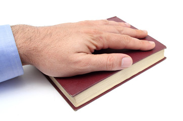 closeup of a hand swearing on a bible