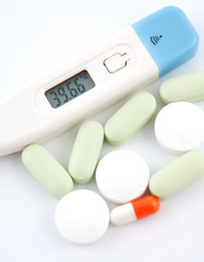 Some medical  pills and digital thermometer