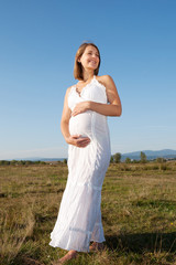 Fototapeta na wymiar Pregnant woman standing on field