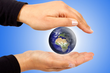 Earth symbol protected by human hands