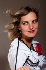 Daydreamed woman in white blouse with red flower