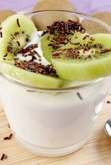 Joghurt in einem Glas mit Kiwischeiben und Schokoladenstreusel
