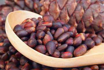 pine nuts in wooden spoon
