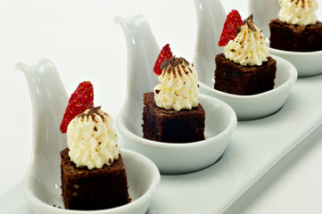 Chocolate brownie Dessert on white porcelain tasting spoons