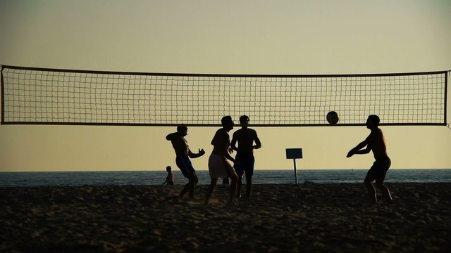 silhouette of volleyball players on the beach at sunset