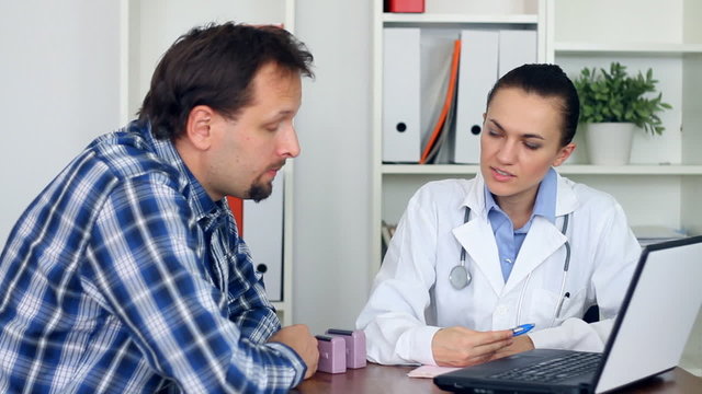 Female doctor telling bad news to male patient in the office