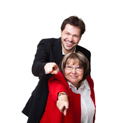 junger Geschäftsmann und ältere Frau zeigen in die Kamera