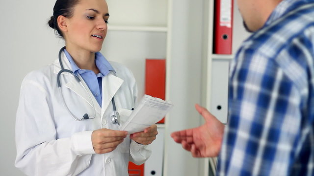 Female doctor giving rx prescription to male patient