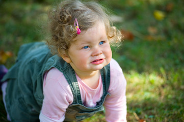 baby is crawling in the fall-meadow