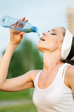 Woman drinking water at outdoors sport