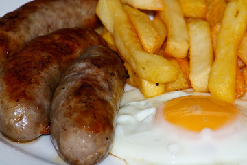 Close up of Sausage, egg and chips.